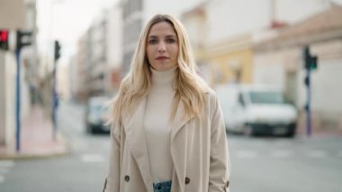 Genç sarışın kadın gülümsüyor. Kendine güvenen, sokakta el sıkışan.