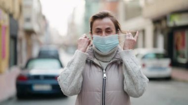 Middle age woman smiling confident wearing medical mask at street