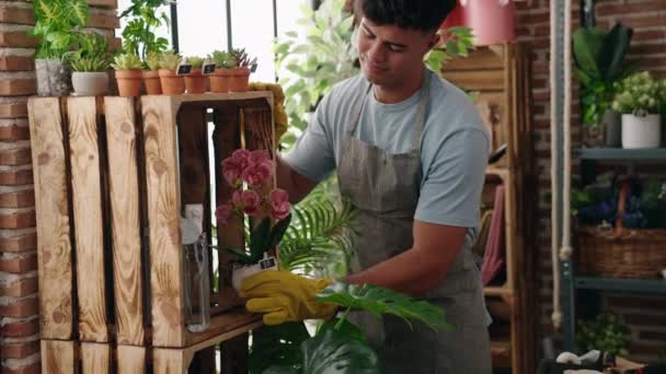 Jonge Spaanse Man Bloemist Glimlachend Zelfverzekerde Holding Plant Bloemenwinkel — Stockvideo