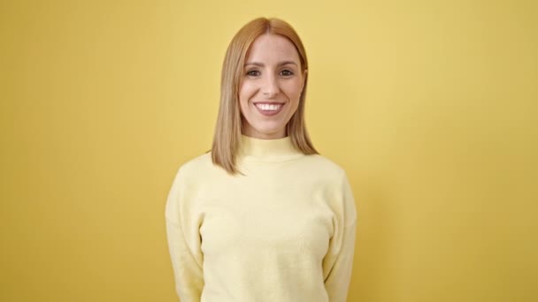 Joven Mujer Rubia Sonriendo Confiada Pie Sobre Aislado Fondo Amarillo — Vídeo de stock