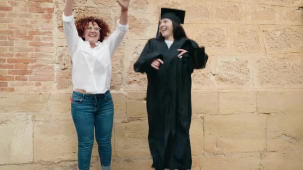 Dos Mujeres Madre Hija Celebrando Graduación Saltando Universidad Del Campus — Vídeo de stock