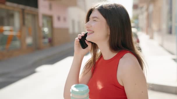Νεαρή Καυκάσια Γυναίκα Μιλάει Στο Smartphone Πίνοντας Καφέ Στο Δρόμο — Αρχείο Βίντεο
