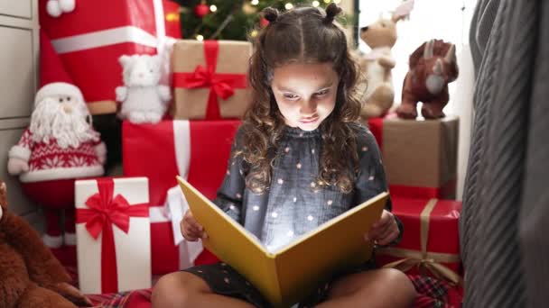 Imádnivaló Spanyol Lány Olvasás Könyvet Padlón Karácsonyfa Otthon — Stock videók