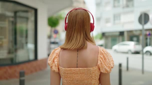 Joven Pelirroja Escuchando Música Caminando Por Calle — Vídeo de stock