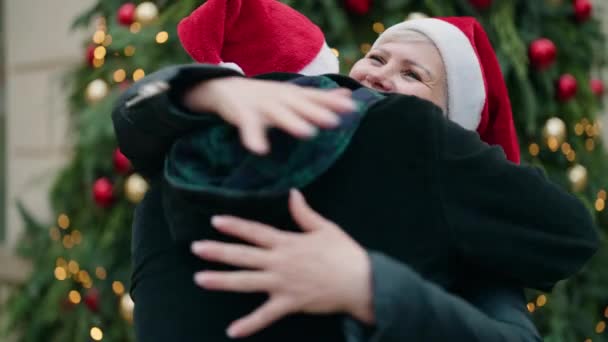 妈妈和儿子站在公园的圣诞树旁互相拥抱 — 图库视频影像