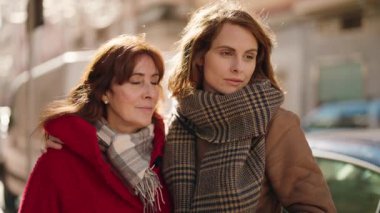 Anne ve kızı gülümsüyor. Kendilerine güveniyorlar. Sokakta birbirlerine sarılıyorlar.
