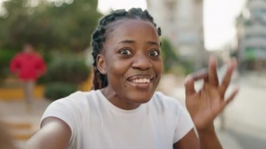 Afro-Amerikalı kadın gülümsüyor. Parkta video araması yaptığından emin.
