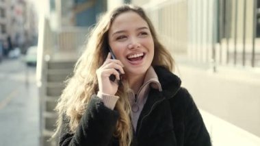 Young beautiful hispanic woman smiling confident talking on smartphone at street