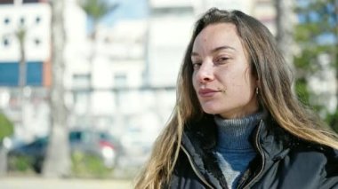 Young caucasian woman standing with serious expression at street