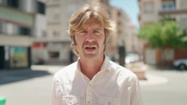 Sokakta konuşan rahat yüzlü genç adam.