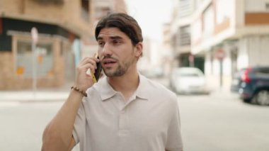 Genç İspanyol adam akıllı telefondan konuşuyor caddede yürürken
