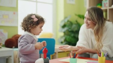 Teacher and toddler playing at kindergarten