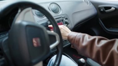 Arabasında oturan genç bir Arap sokakta radyoyu açıyor.