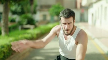 Genç İspanyol adam parkta karate dövüşçüsü eğitimi alıyor.
