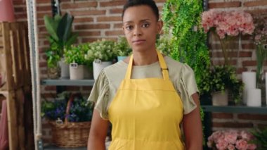 African american woman florist smiling confident holding open blackboard at florist