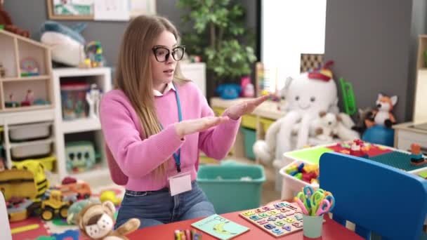 Junge Blonde Kindergärtnerin Bittet Schweigen Kindergarten — Stockvideo