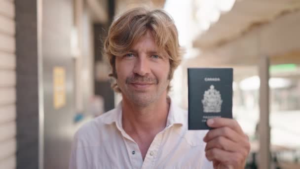 Молодой Человек Улыбается Уверенно Указывая Пальцем Паспорт Улице — стоковое видео