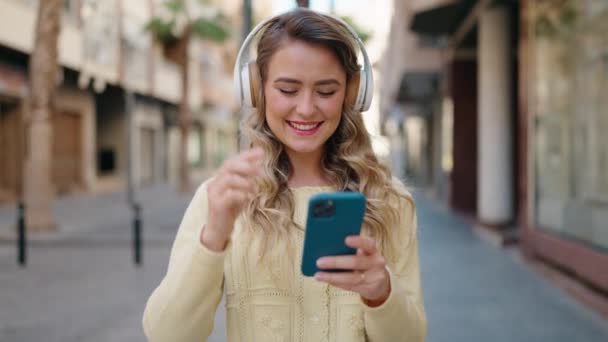 Jong Blond Vrouw Glimlachen Zelfverzekerd Luisteren Naar Muziek Straat — Stockvideo