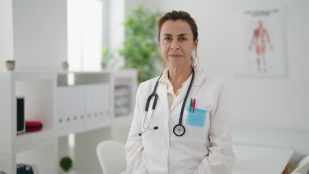 Kobieta Średnim Wieku Mundurze Lekarza Robi Symbol Serca Rękami Klinice — Wideo stockowe