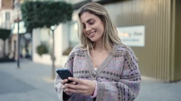 Młoda Blondynka Uśmiecha Się Pewnie Pomocą Smartfona Ulicy — Wideo stockowe