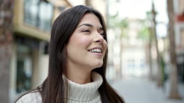 Young beautiful hispanic woman breathing with closed eyes at street