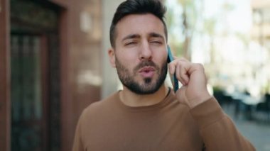 Genç İspanyol adam gülümsüyor. Kendine güveniyor. Sokakta akıllı telefondan konuşuyor.