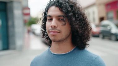 Young latin man smiling confident standing at street