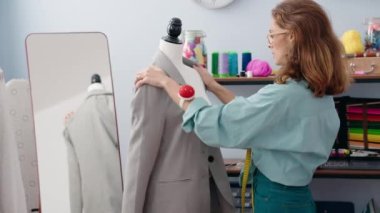 Genç, güzel İspanyol kadın terzi dükkanında kendine güvenen ve gülümseyen bir terzi.