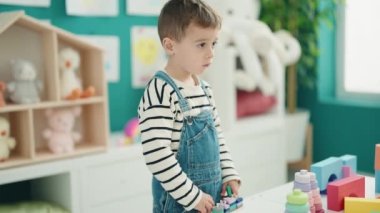 Anaokulunda inşaat bloklarıyla oynayan sevimli beyaz çocuk.