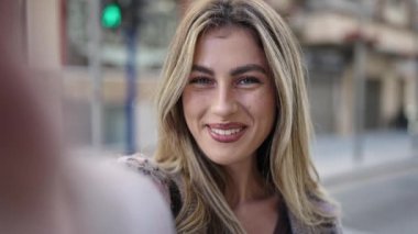 Genç sarışın kadın gülümsüyor. Kendine güveni tam.