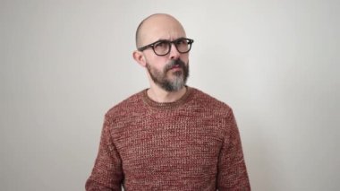 Genç, kel bir adam, izole edilmiş beyaz arka planda parmağını hareket ettirmiyor.