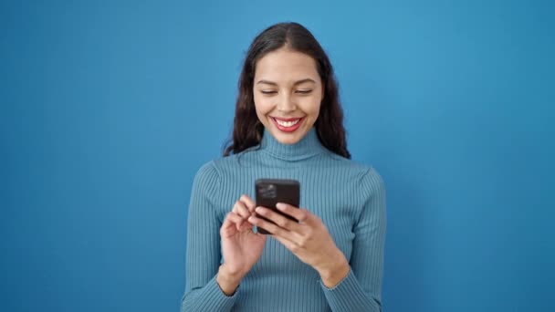 Jovem Bela Mulher Hispânica Usando Smartphone Sobre Fundo Azul Isolado — Vídeo de Stock