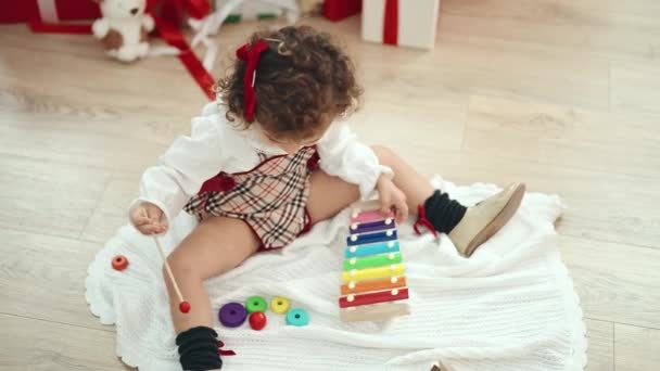 Adorable Hispanic Girl Playing Xylophone Sitting Floor Christmas Tree Home — Vídeo de stock
