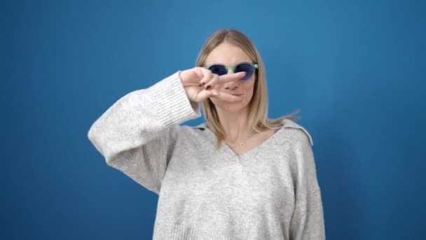 Young Blonde Woman Smiling Dancing Wearing Sunglasses Isolated Blue Background — 비디오
