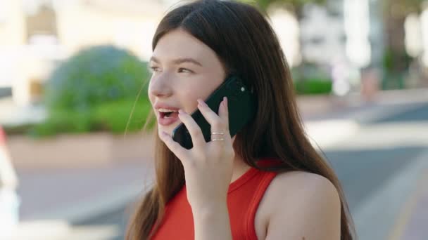 公園でスマートフォンで自信を持って話す若い白人女性 — ストック動画