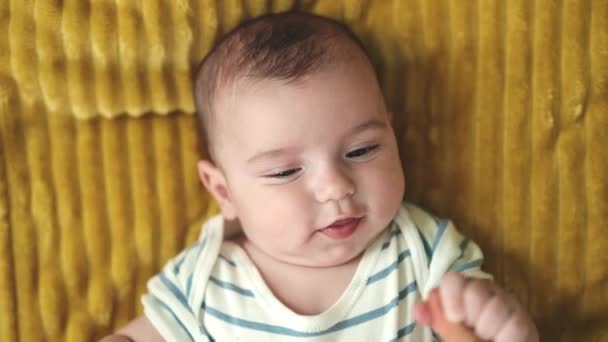 可爱的高加索婴儿躺在沙发上 微笑着为家里的痒而哭泣 — 图库视频影像