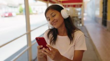 Sokak ortasında müzik dinleyen ve dans eden genç, güzel İspanyol kadın.