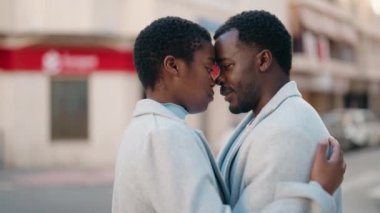 African american couple kissing and hugging each other at street