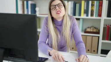 Kütüphane üniversitesinde belgeye yazı yazan genç sarışın kadın.