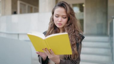 Sokakta kitap okuyan genç İspanyol kadın.