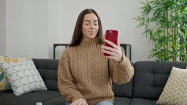 Genç ve güzel İspanyol kadın evde online tıbbi danışmanlık alıyor.