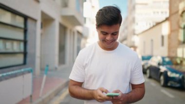 Sokakta akıllı telefon kullanan, kendine güvenen genç bir İspanyol.