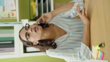 Young african american woman business worker talking on smartphone working at office