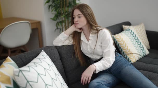 Young Blonde Woman Sitting Sofa Serious Expression Home — Wideo stockowe
