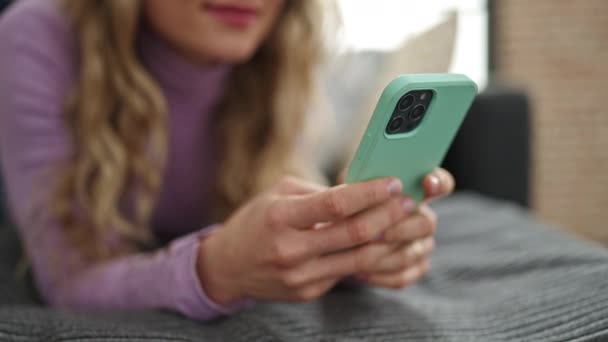 Mujer Rubia Joven Usando Teléfono Inteligente Tumbado Sofá Casa — Vídeo de stock
