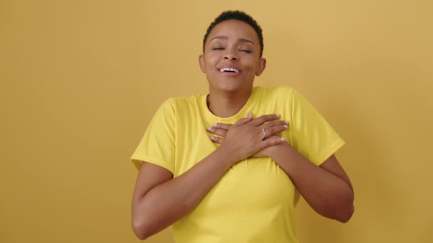 Африканская Американка Улыбается Уверенно Руками Сердце Изолированном Желтом Фоне — стоковое видео