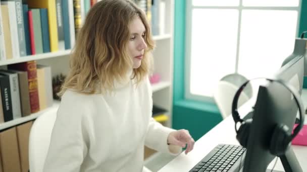 在图书馆大学利用计算机学习的金发女学生 — 图库视频影像