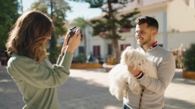 Genç çift parkta profesyonel kamera kullanarak fotoğraf çekiyor.