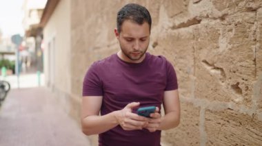 Young man smiling confident making selfie by the smartphone at street