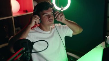 Oyun odasında bilgisayar kullanarak video oyunu oynayan İspanyol asıllı genç adam.